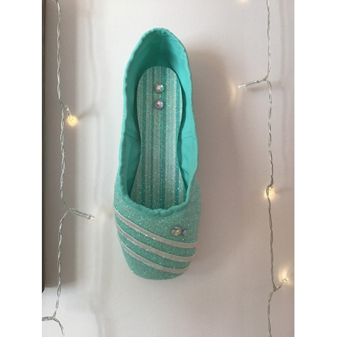 A green ballet shoe with Christmas lights around it