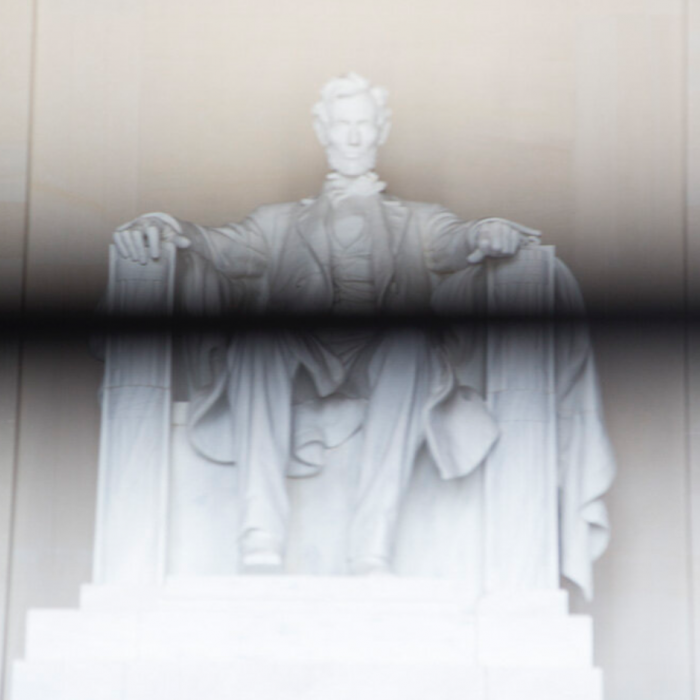 Portrait of the Lincoln Memorial with a black line struck through the middle.