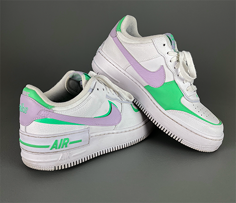 A pair of white, purple, and green Nike sneakers