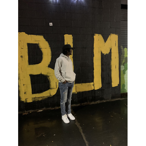 Man standing in front of a BLM mural