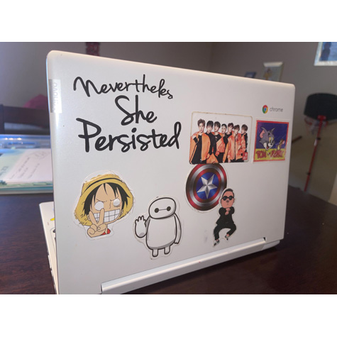 Image of a white laptop with stickers on it