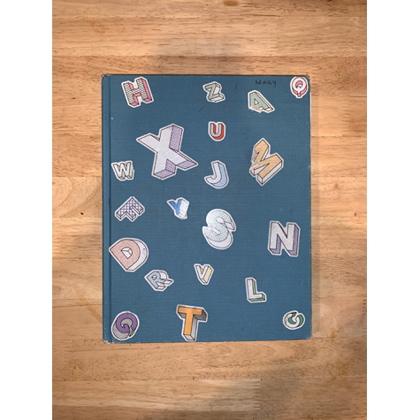 A blue sketchbook with stickers on the front