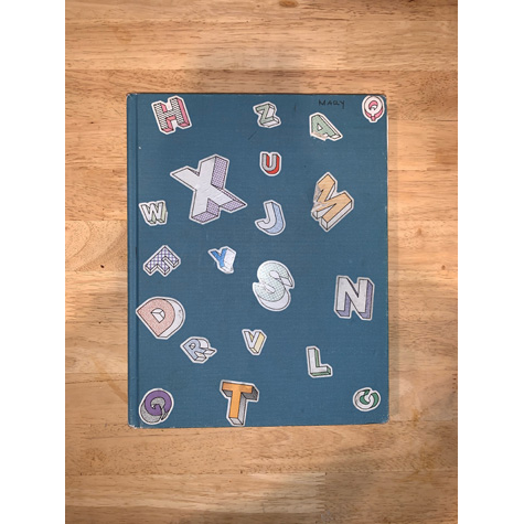 A blue sketchbook with stickers on the front