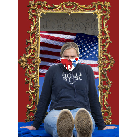 A woman in a mask with the American flag on it sitting in front of a mirror that reflects another American flag
