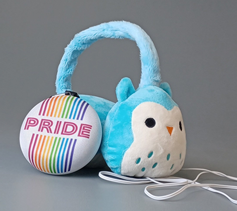 Plush headphones in the shape of an owl with a round speaker with the word PRIDE written in rainbow colors