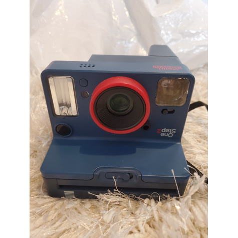 Polaroid camera sitting on a carpet