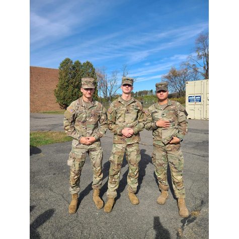 Three men in military uniforms posing in front of the camera