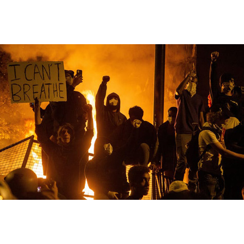 A group of protesters, one is holding. sign that says I can't breathe.