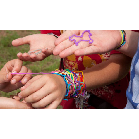 3 female hands, one holding purple hairbands and the other wearing hairbands as bracelets around her wrist.