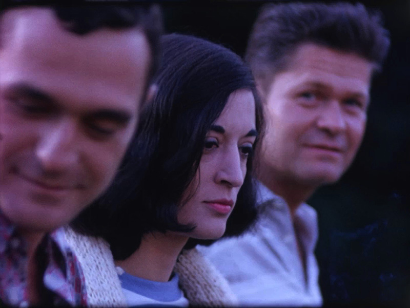 A film still of three people in profile, one looking at the camera, the others looking in different directions