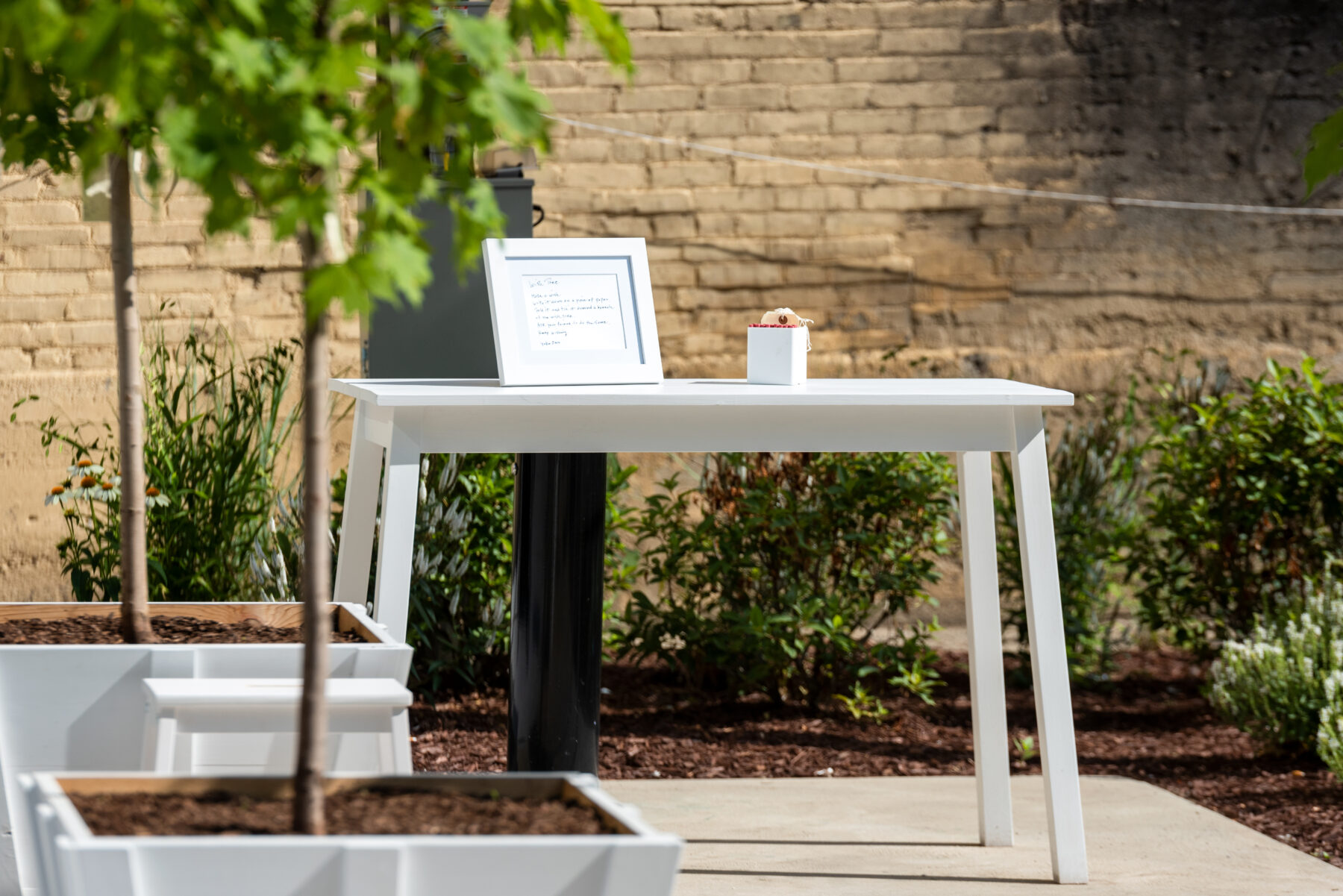 Table in park-like setting with framed instructions, paper tags, and pencils.