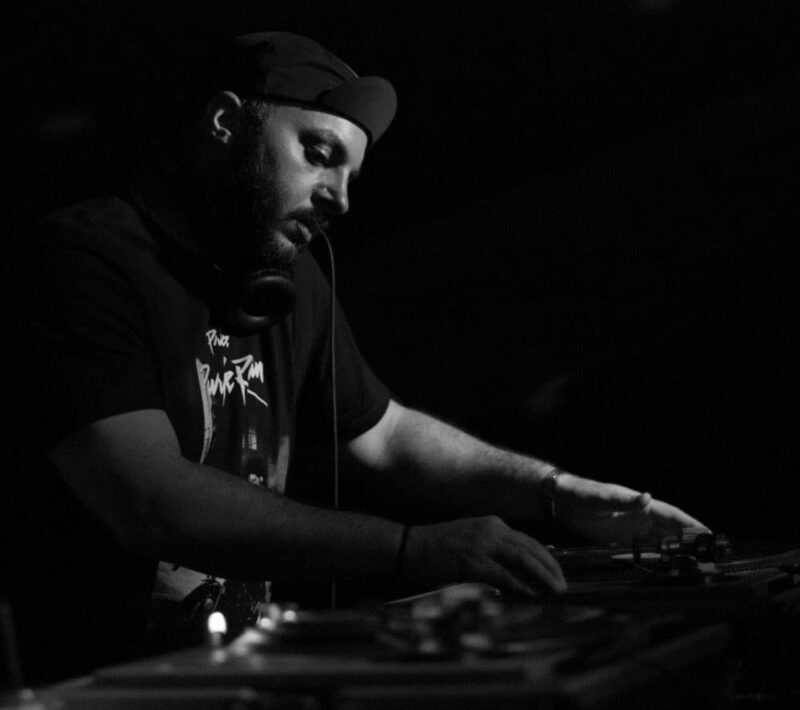 Black and white photo of DJ Pretty Tony spinning records.