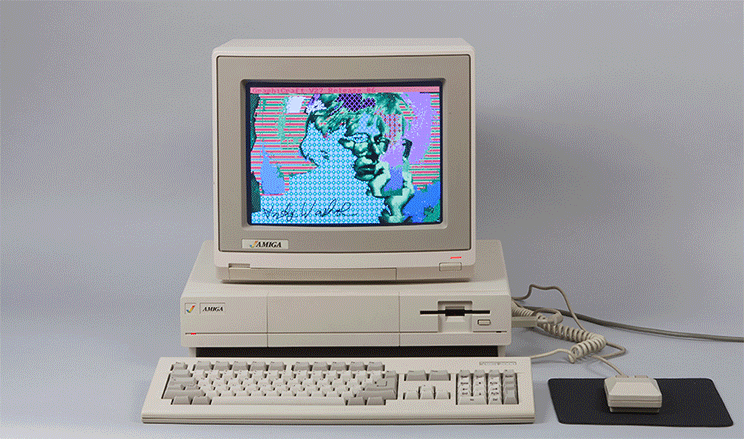An old Amiga computer with several colorful works of art by Andy Warhol on the screen.