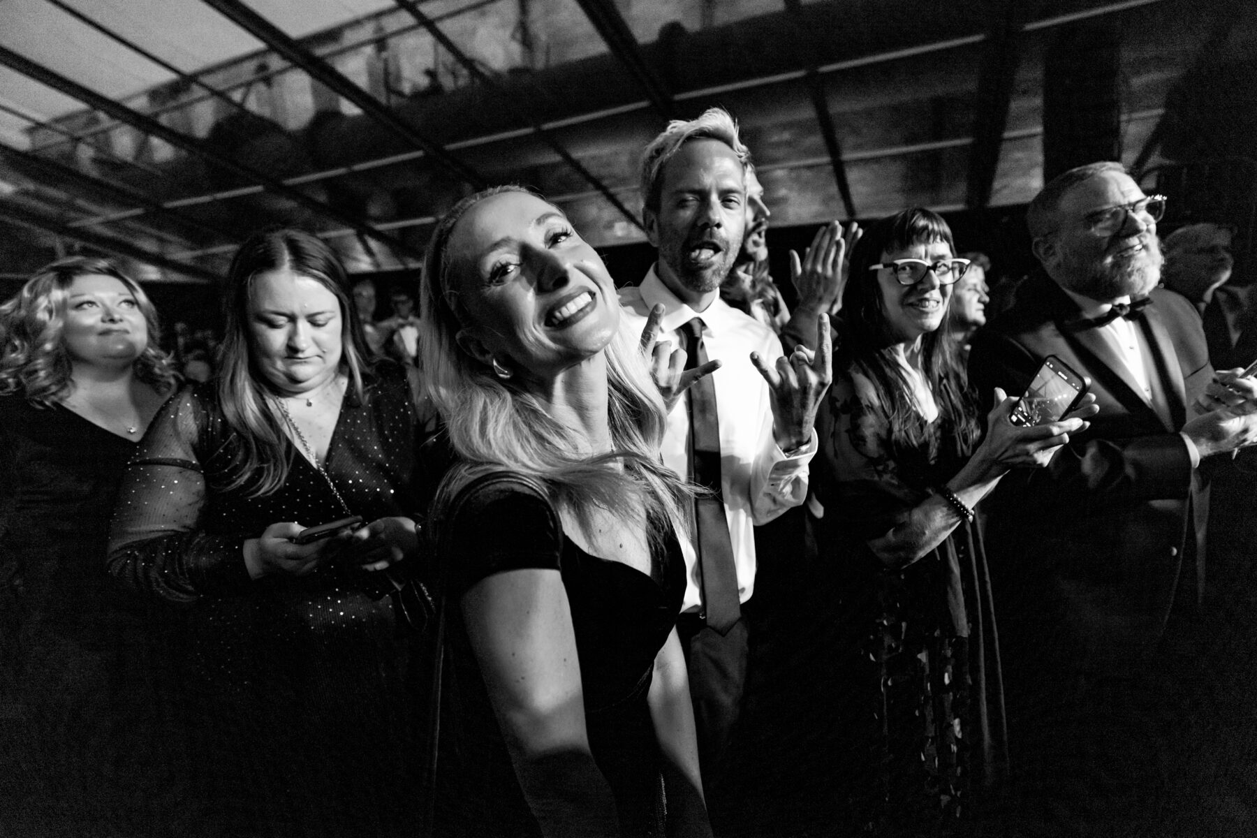 Two people in a crowd smile at the camera. Black and White