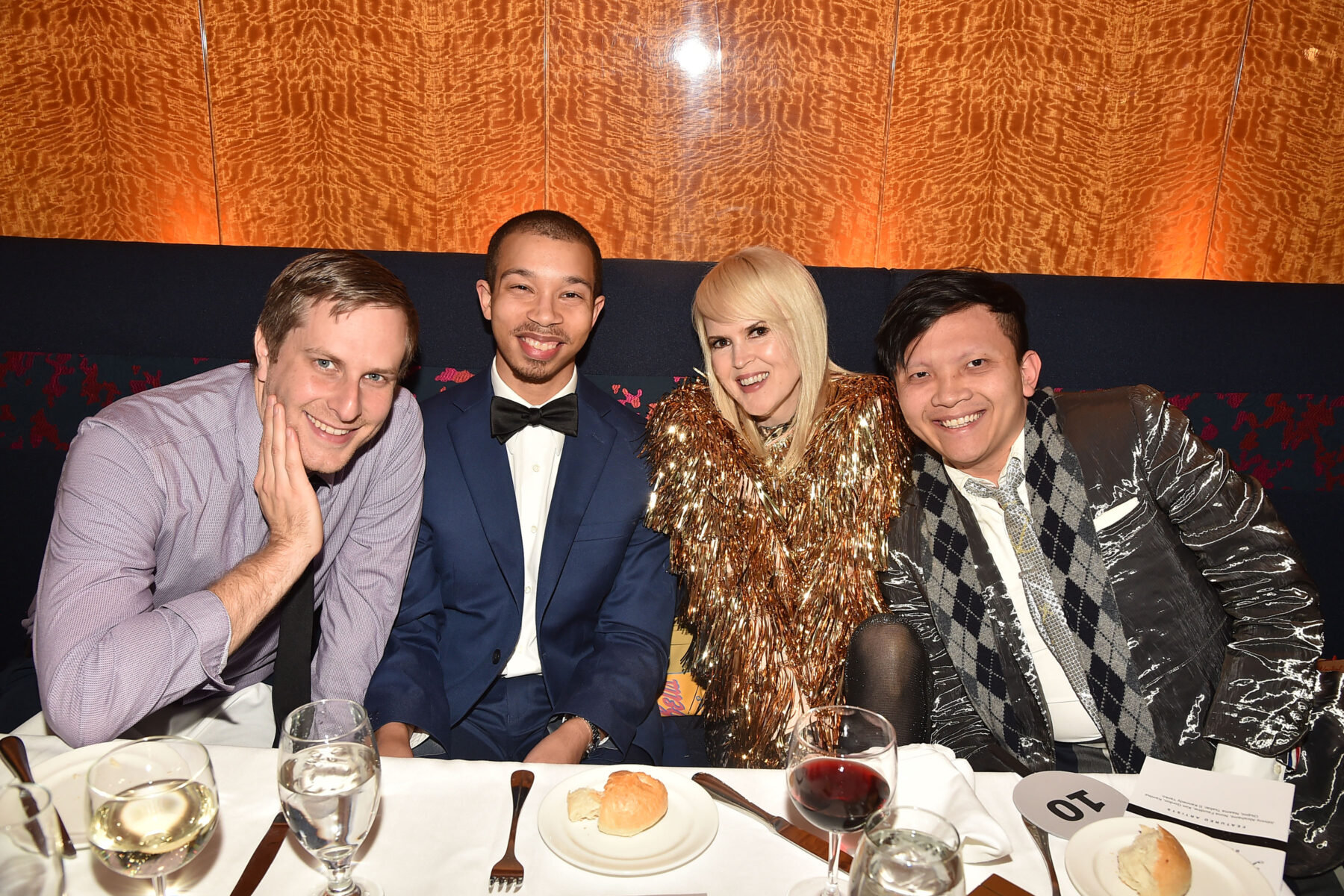 Four people pose for a group photo at a table