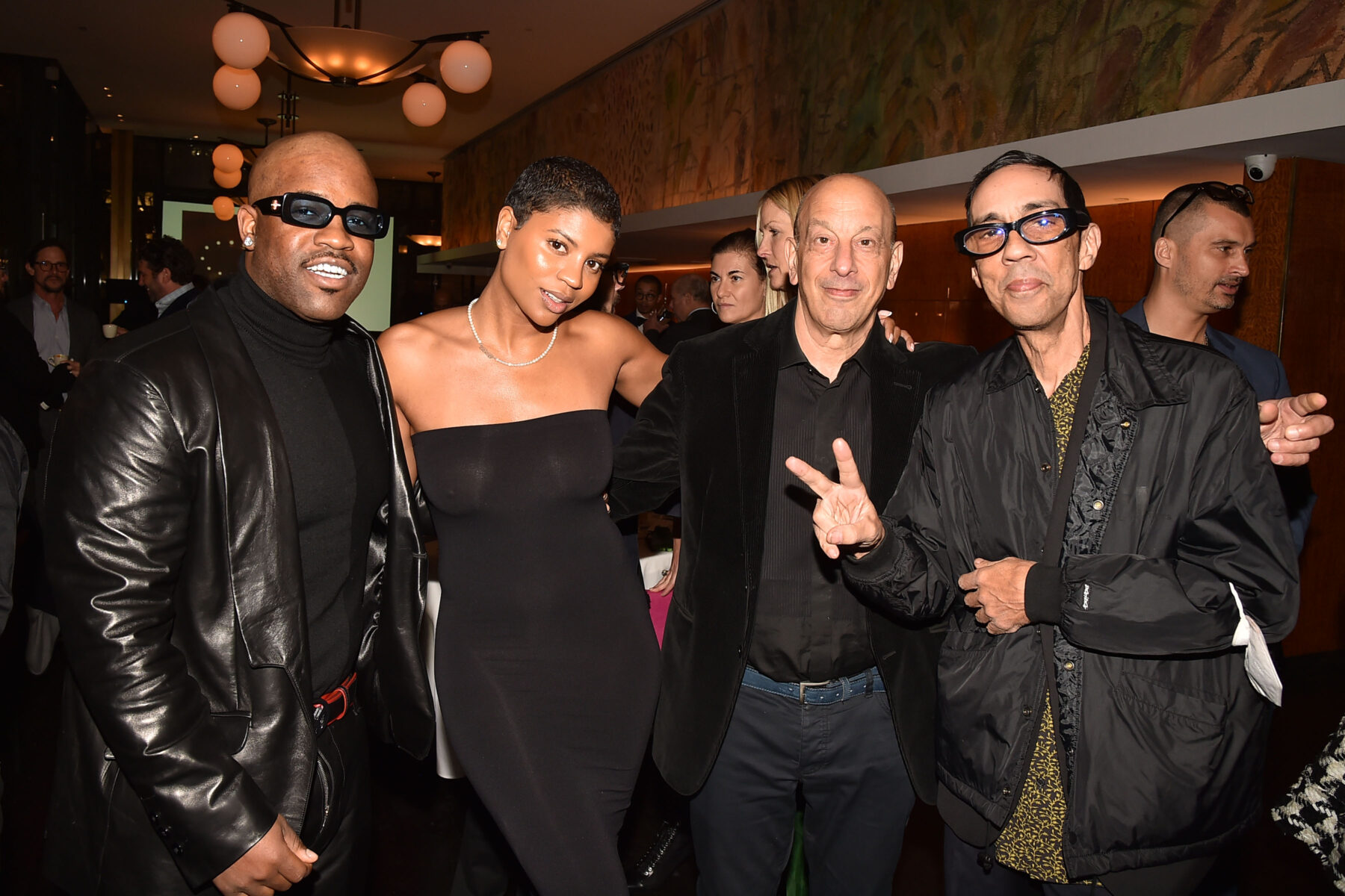 Four people pose for a group photo at a party