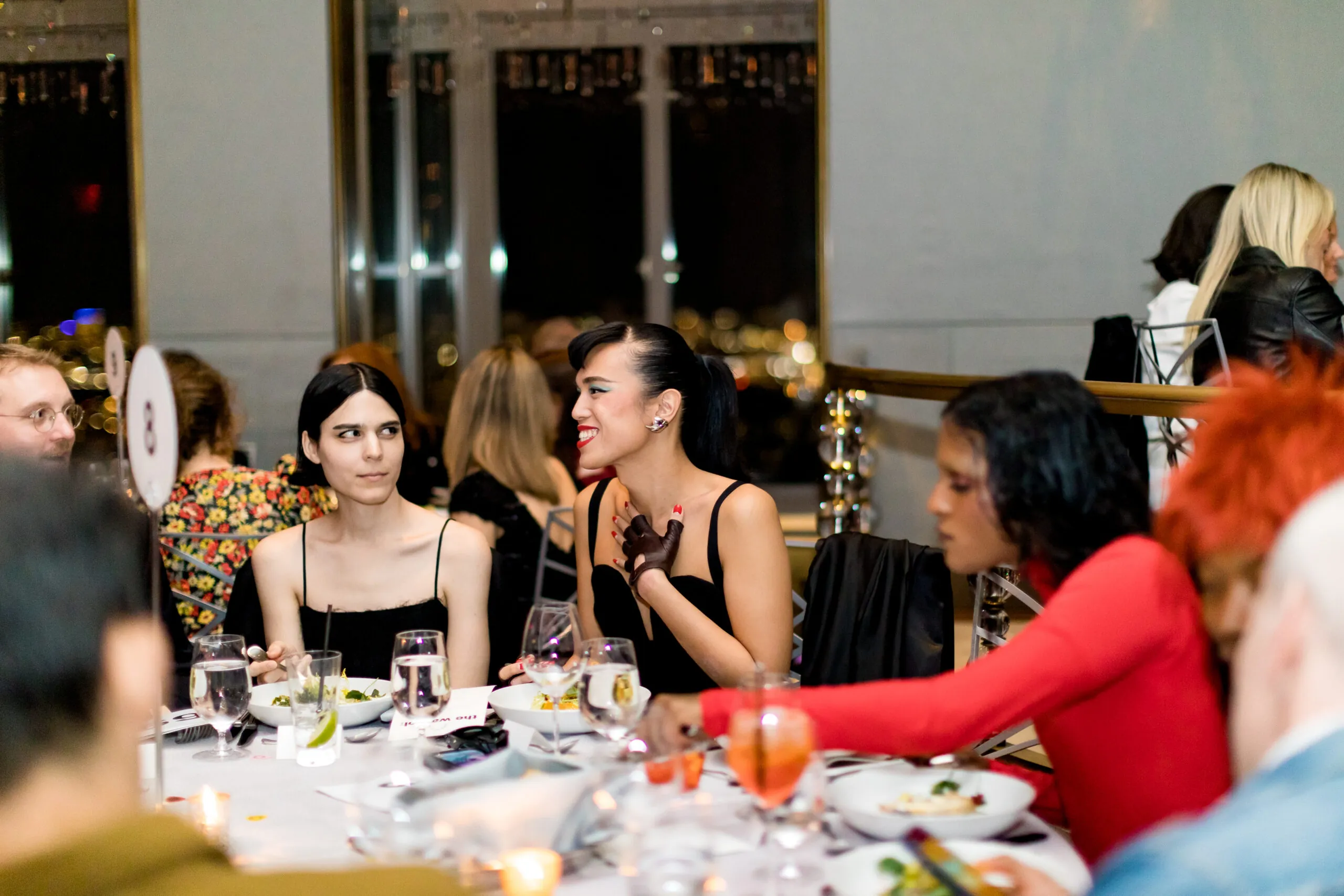 3 people gathered around a table in formal wear