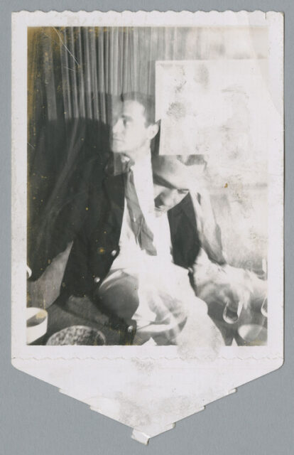 A Polaroid print out of two photos over-laying each other. On the left, a man reclines on a couch, suit jacket unbuttoned and paying attention to something to his right. On the left, the same man's head can be seen looking down. It looks almost as if the head is coming out of the previous image's chest.