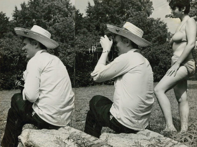 Two combined photo of Andy Warhol sitting on a rock looking to the right, the left most having a woman behind him. The right most Andy Warhol has a camera to his eye. The woman is wearing a bikini top.