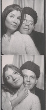 a black and white photo booth strip. a man and a woman pose intimately together, the woman in front. The woman wears a white sweater, while the man wears a black shirt.